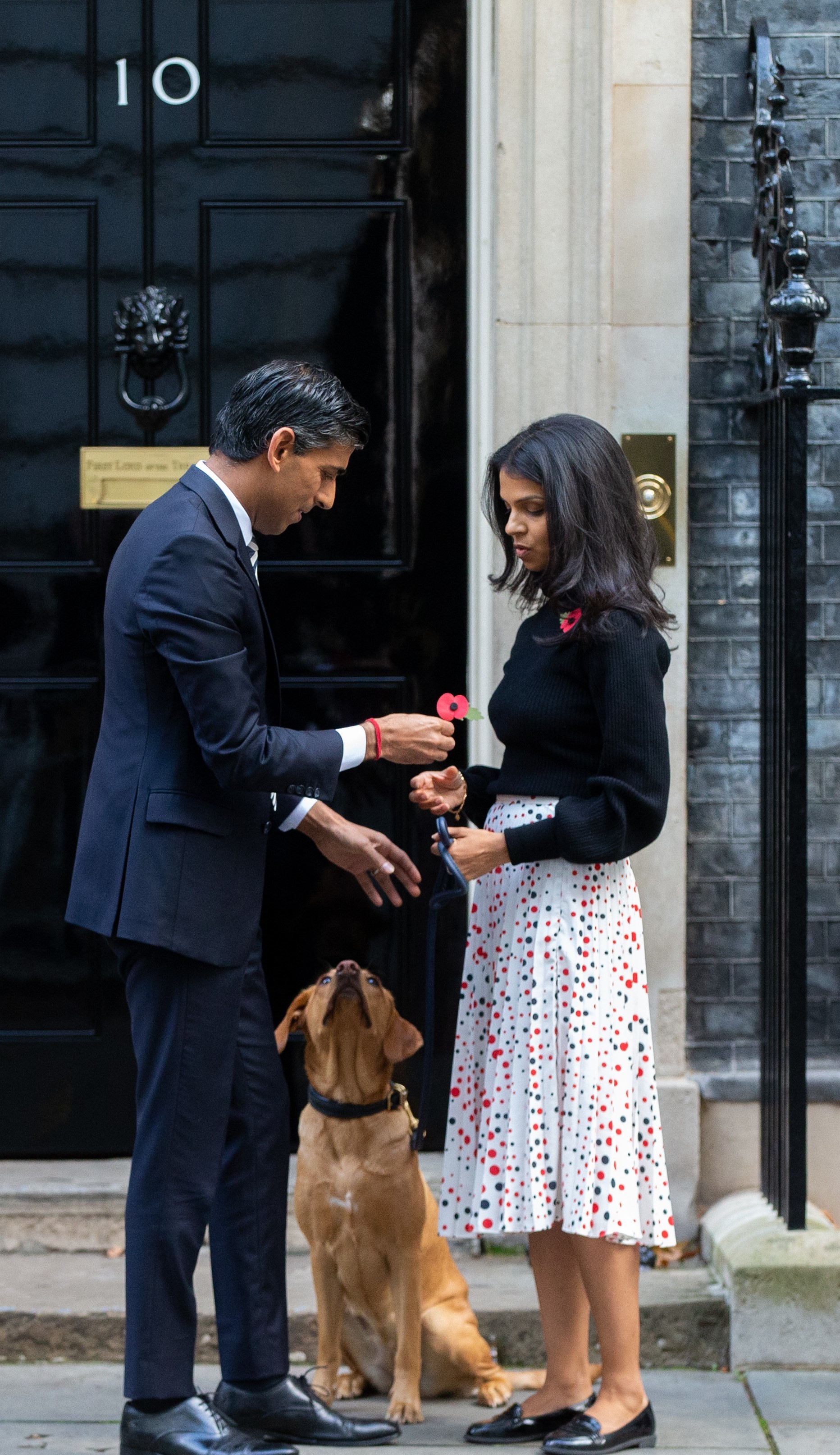 Akshata Murthy con su marido Rishi Sunak en la puerta de Downing Street con su perro.