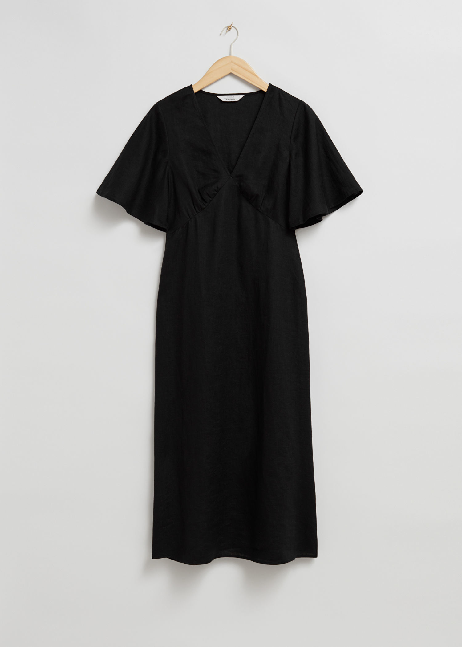 Vestido negro con escote en uve de & Other Stories (89 euros).
