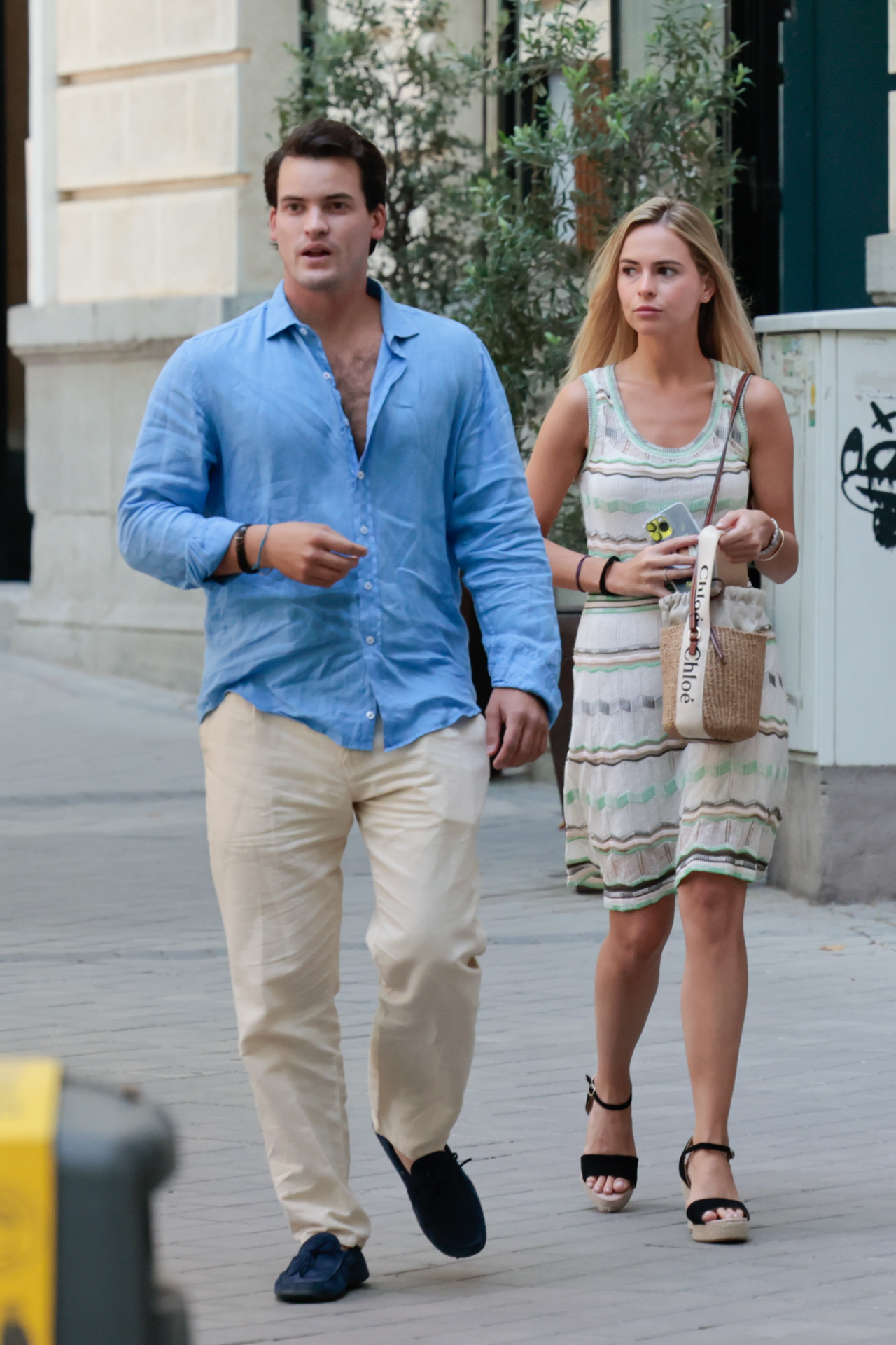 Jaime Onieva junto a su novia con vestido con print y sandalias de cuña negras.