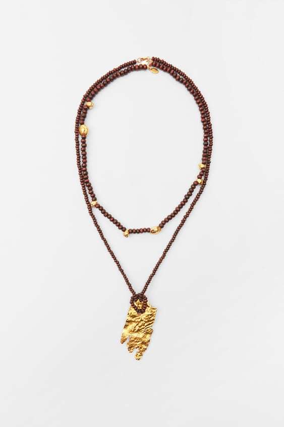 Collar de madera con colgante dorado, de Zara (17,95 euros).