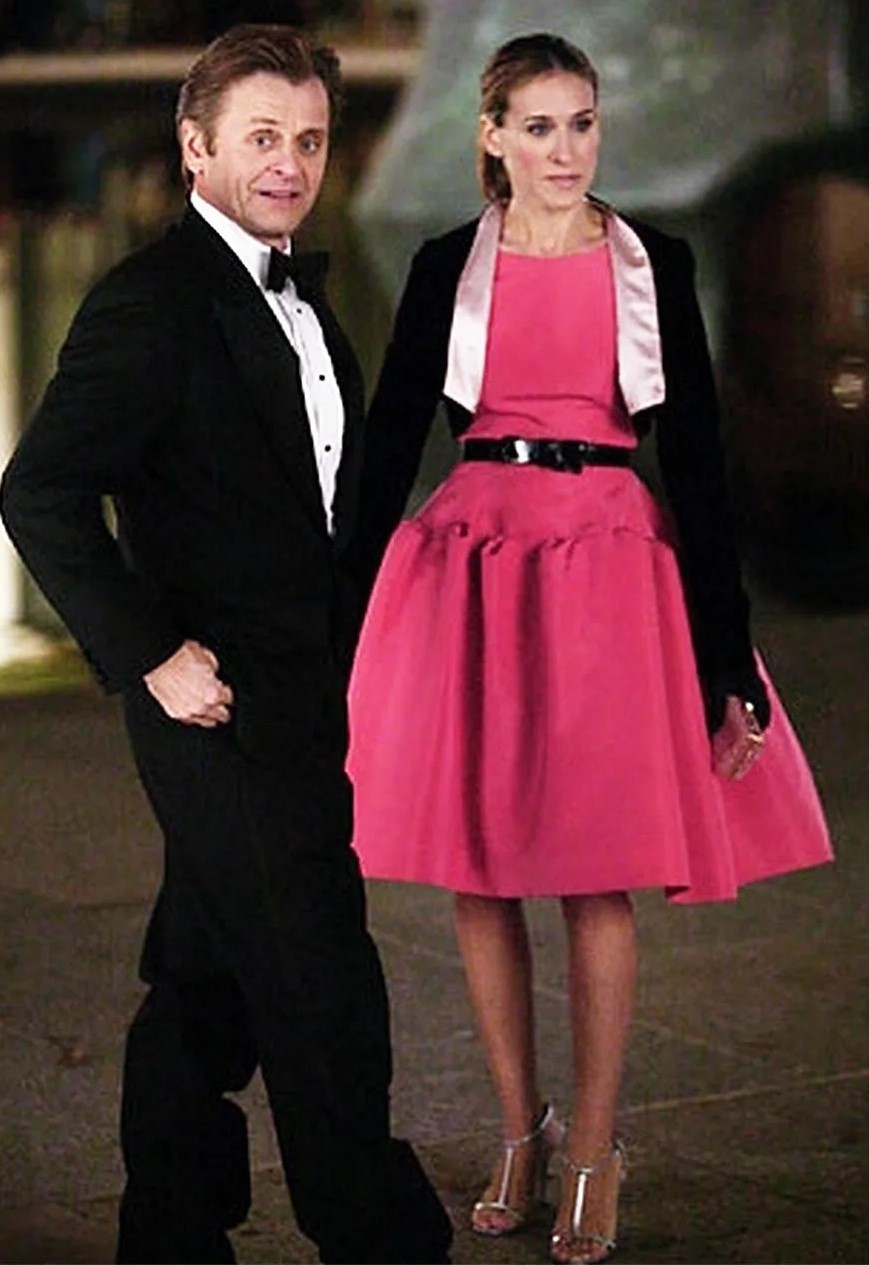 Carrie Bradshaw con un vestido fucsia de Oscar de la Renta, uno de sus looks míticos de Sexo en Nueva York.