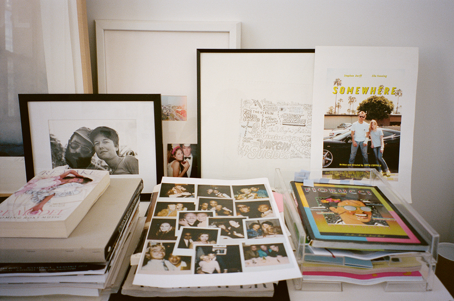 Arriba,su mesa de trabajo presidida por una fotografía de sus padres, Eleanor y Francis Ford Coppola.