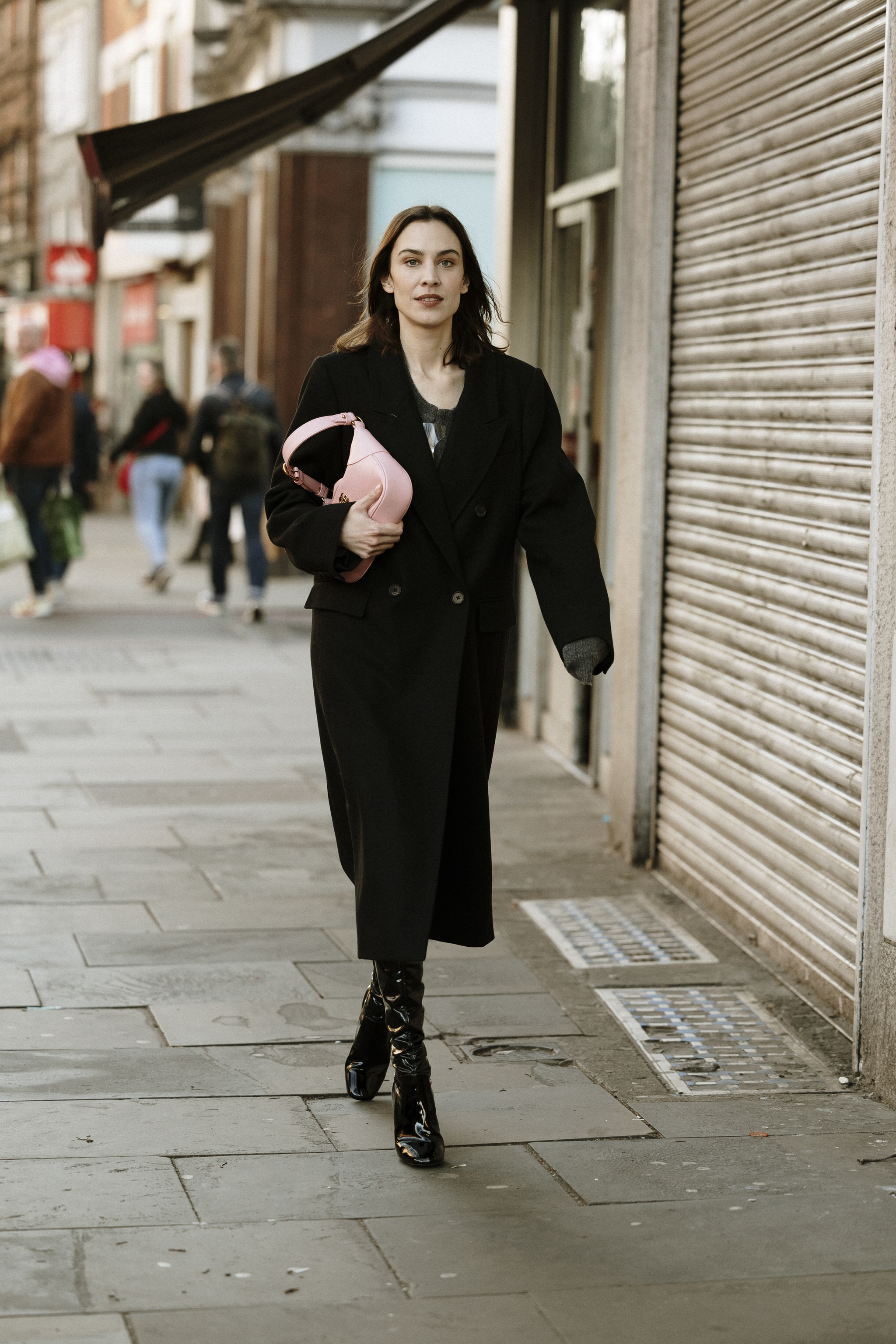 Alexa Chung con abrigo negro de corte masculino.