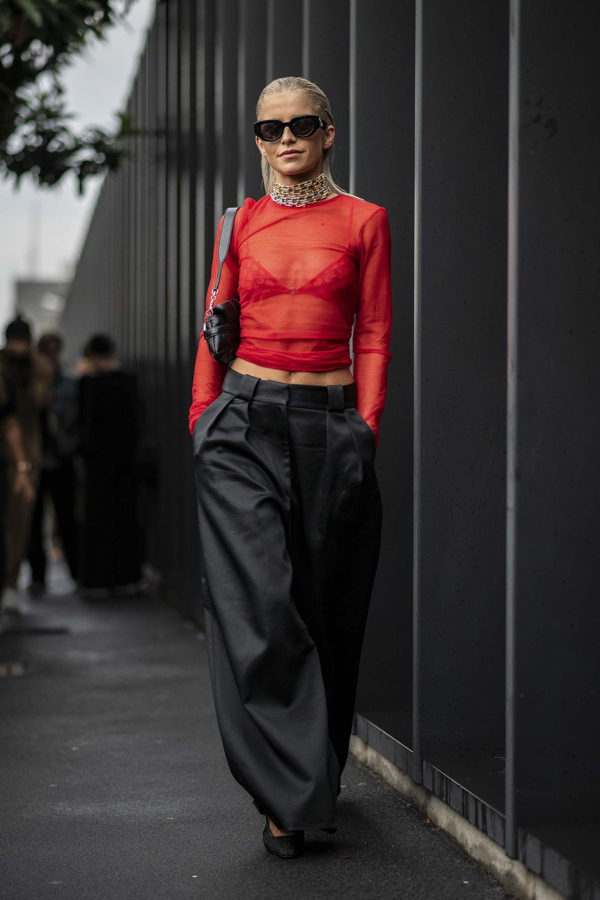 Top transparente rojo de Gucci con pantalón ancho negro.
