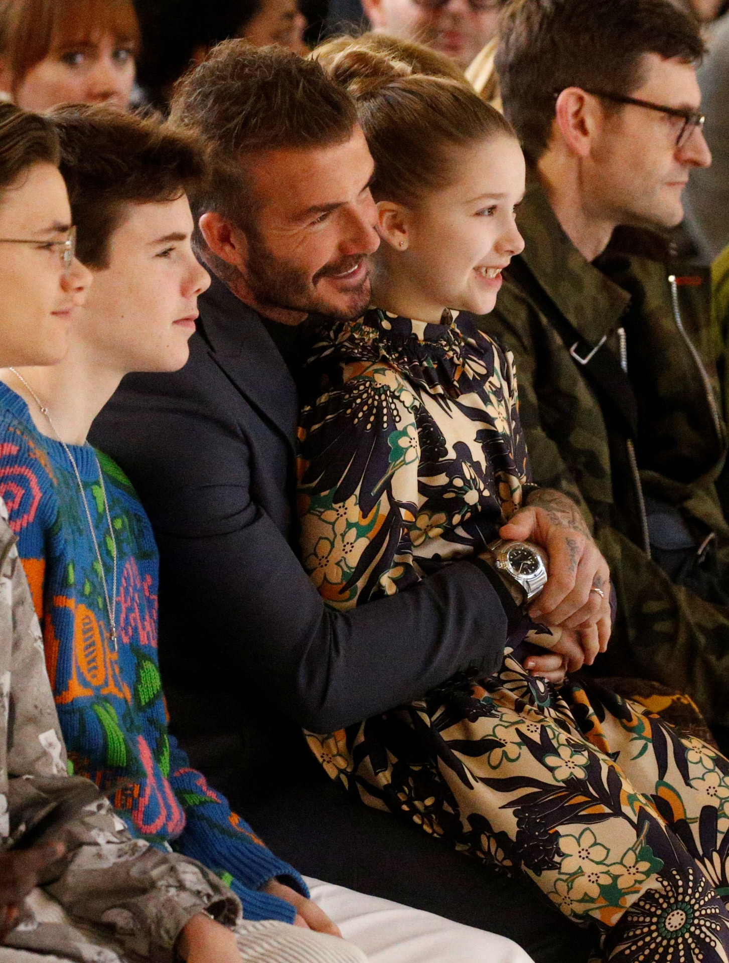 David Beckham cons sus hijos Romeo, Cruz y Harper presenciando un desfile de VictoriaBeckham en 2020.