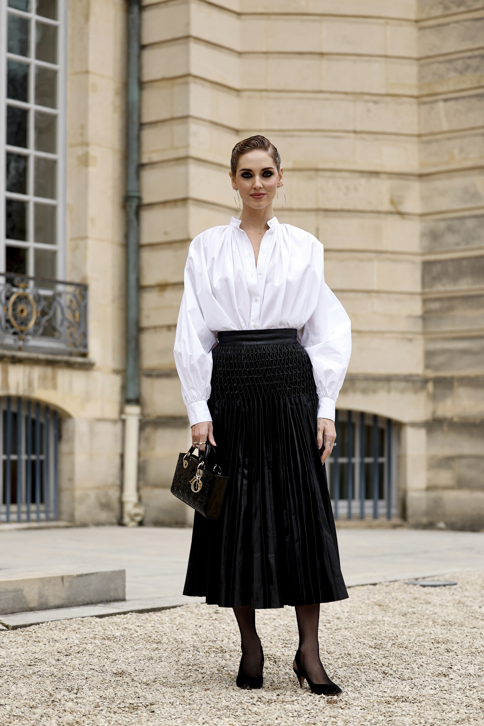 Cómo combinar las medias:Chiara Ferragni con medias y falda midi negra.