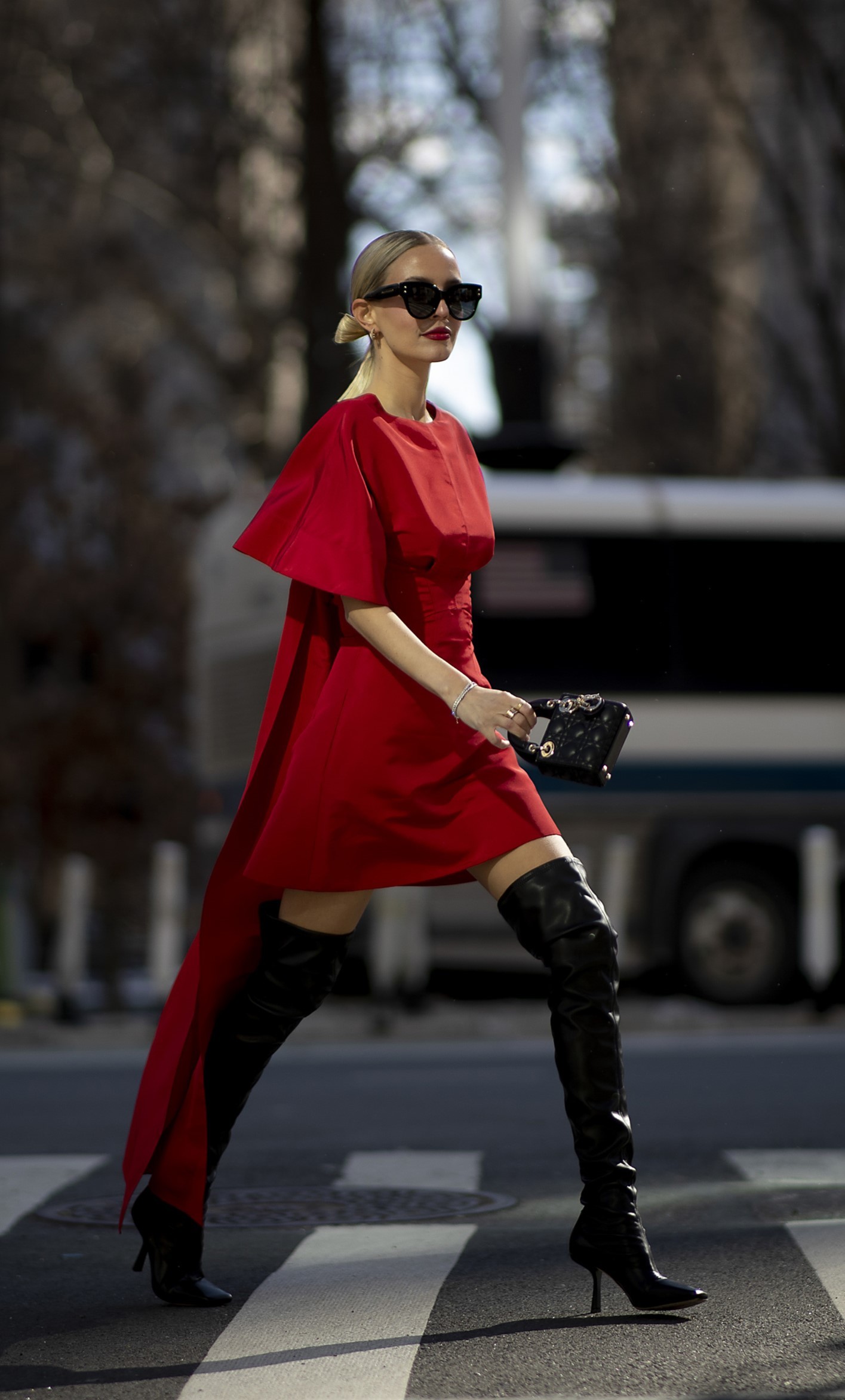 Vestido rojo corto con lazada a modo de cola y botas mosqueteras.