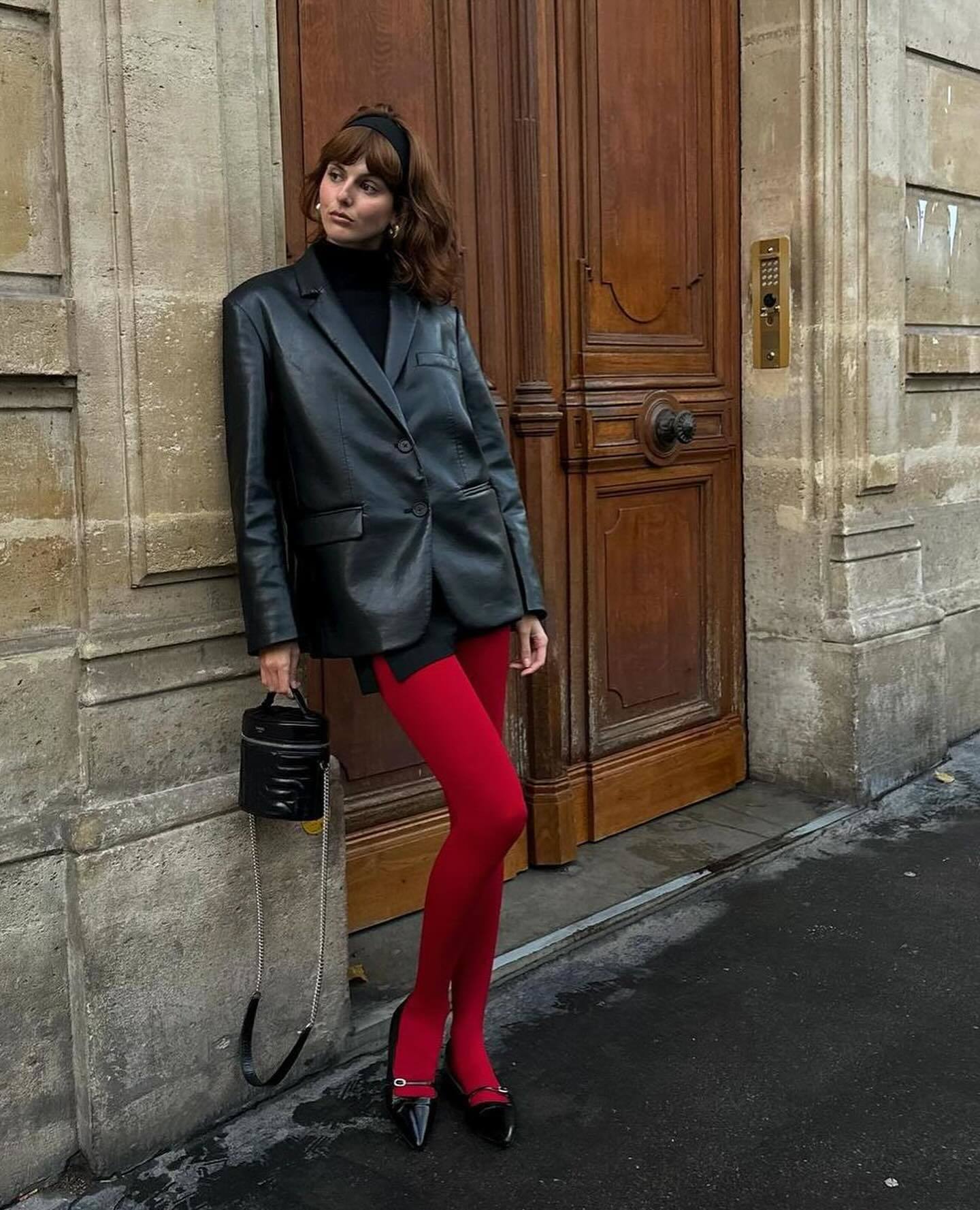 La modelo Justine Soranzo con blazer oversize y mini con medias rojas y manoletinas negras.