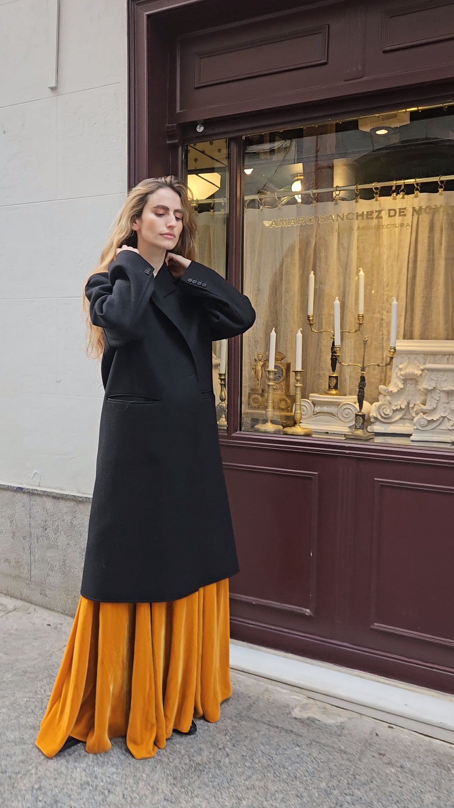 Alejandra con abrigo negro y falda de Dior.