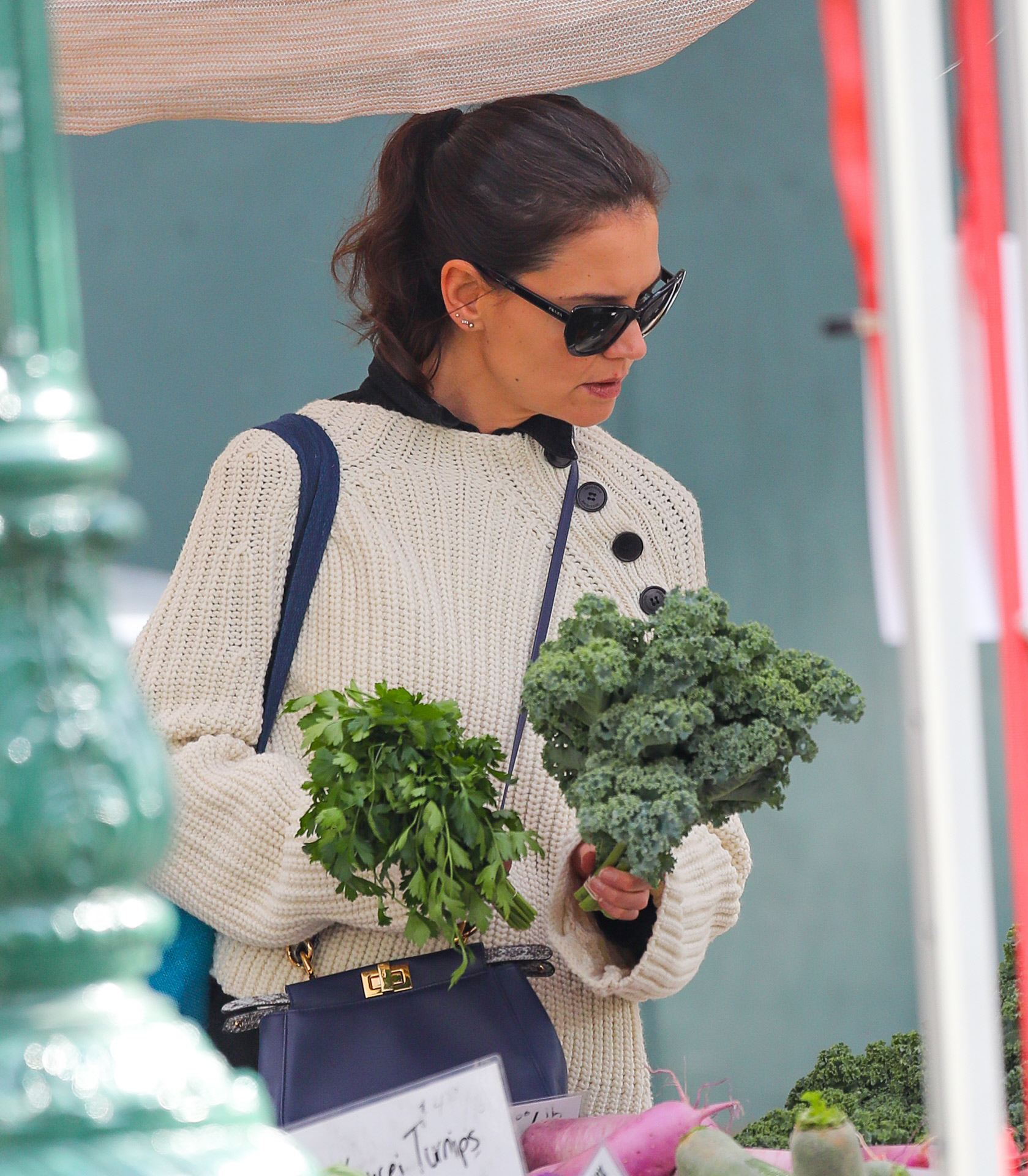 Katie Holmes comprando verduras de hoja verde ricas en vitamina E como el brócoli.