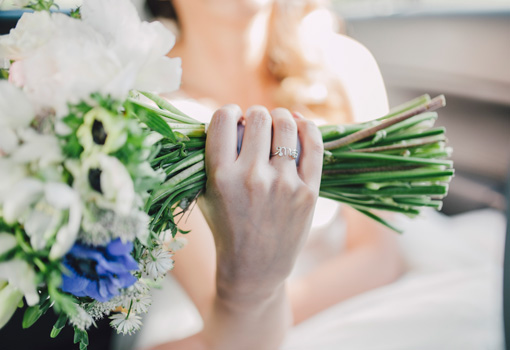 Una novia con su bouquet nupcial en la mano