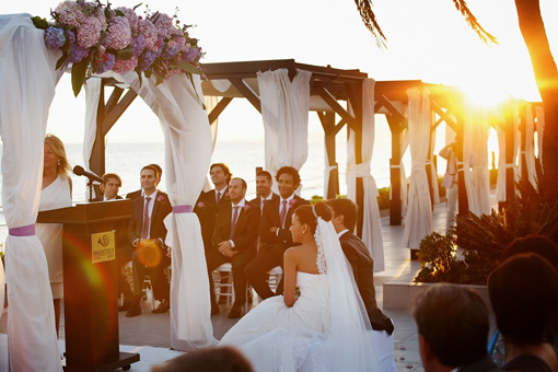 Invitados a una boda bajo una pérgola frente al mar