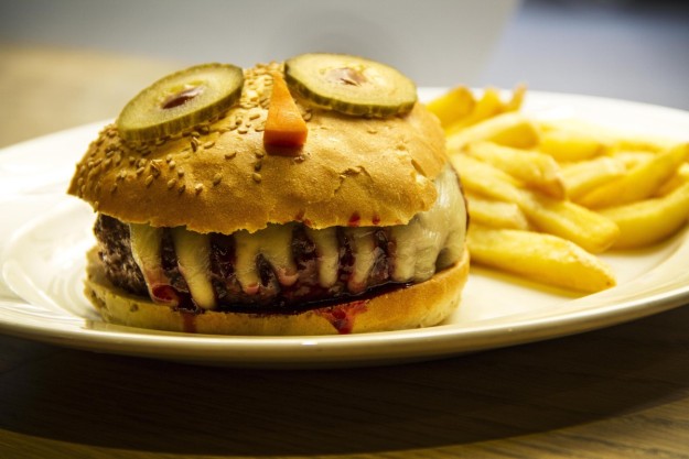 Una hamburguesa con los ingredientes colocados como si fuese una cara. 