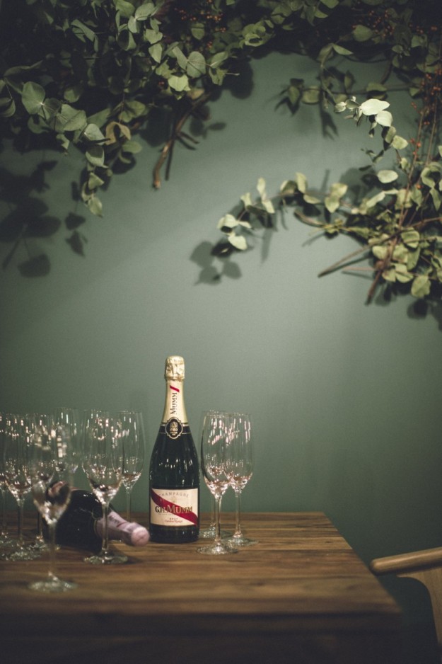 Una mesa con copas y una botella de champán. 