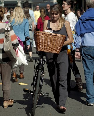 Chica con bicicleta y teléfono móvil en la mano.