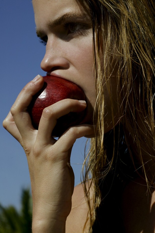 Chica mordiendo una manzana.