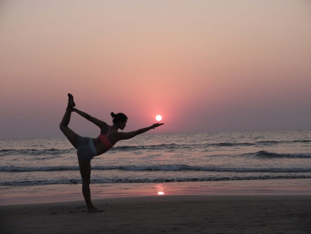 Xuan-Lan realizando yoga en la playa.